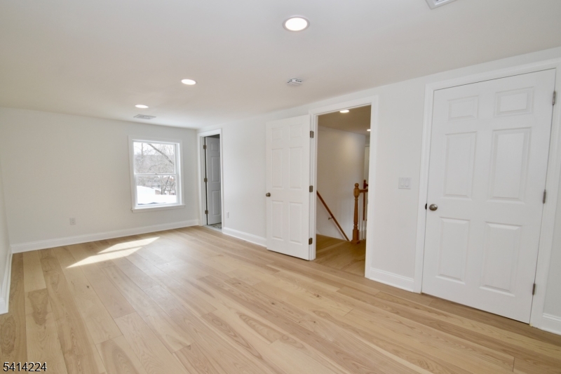 5612 Berkshire Valley Road Oak Ridge, NJ 07438 - Photo 12 of 19 an empty room with wooden floor and a hallway