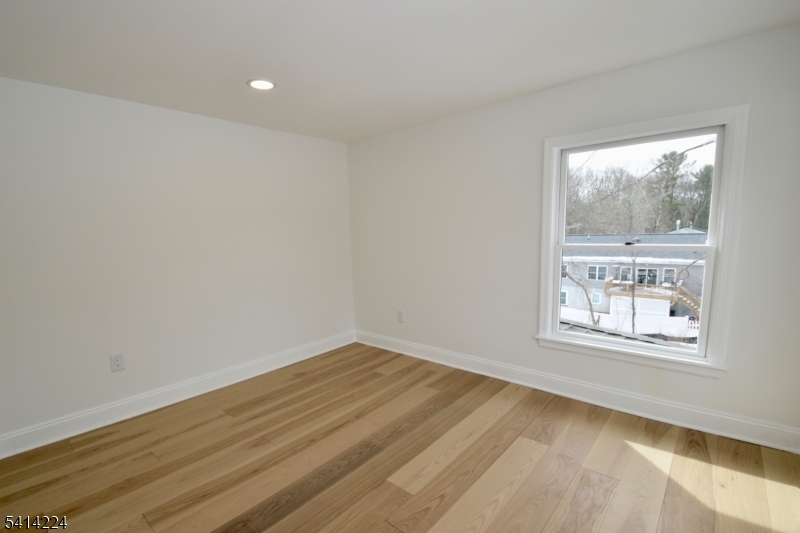 5612 Berkshire Valley Road Oak Ridge, NJ 07438 - Photo 15 of 19 an empty room with wooden floor and windows