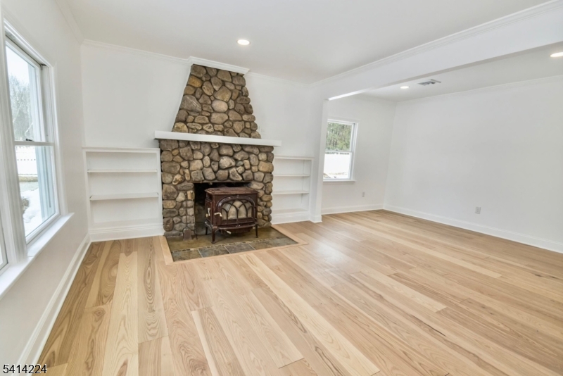5612 Berkshire Valley Road Oak Ridge, NJ 07438 - Photo 4 of 19 wooden floor fireplace and windows in an empty room