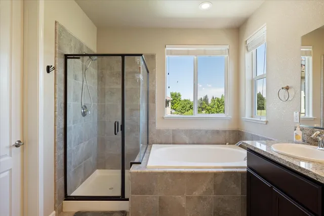 a bathroom with a granite countertop bathtub shower and sink