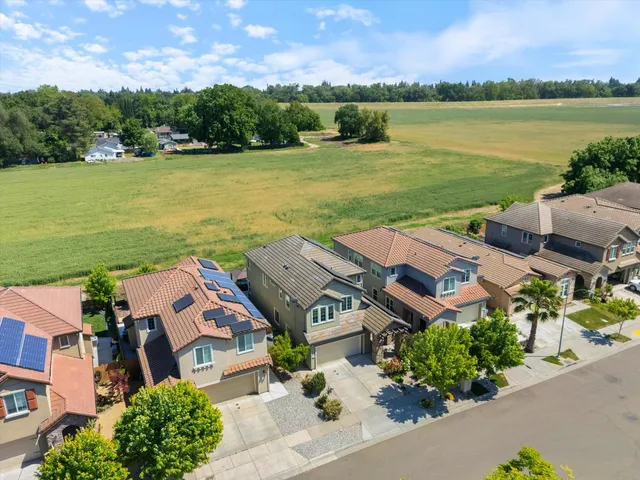 an aerial view of a house with a garden and lake view