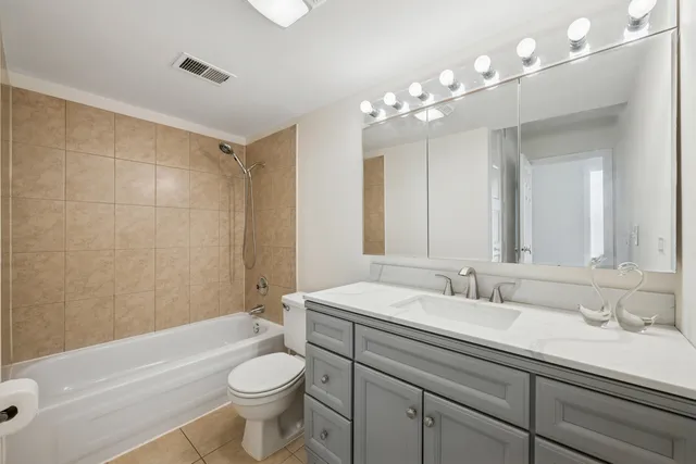 a bathroom with a sink a toilet a mirror a vanity and bathtub