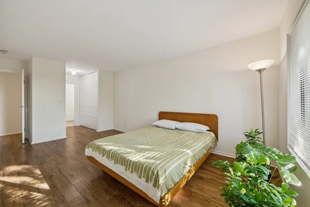 a bedroom with a bed and a potted plant