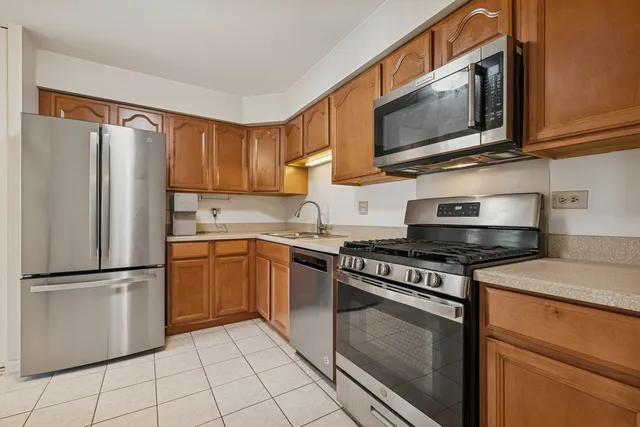 a kitchen with stainless steel appliances granite countertop a stove top oven microwave and refrigerator