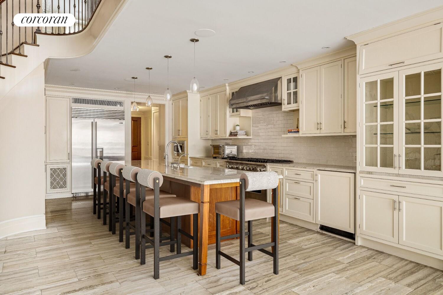 435 East 87th Street Manhattan, NY 10128 - Photo 15 of 36 a kitchen with stainless steel appliances granite countertop a table chairs sink and cabinets