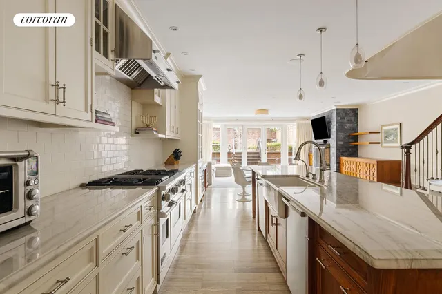 a kitchen with stainless steel appliances granite countertop a stove top oven a sink dishwasher and a refrigerator with wooden floor