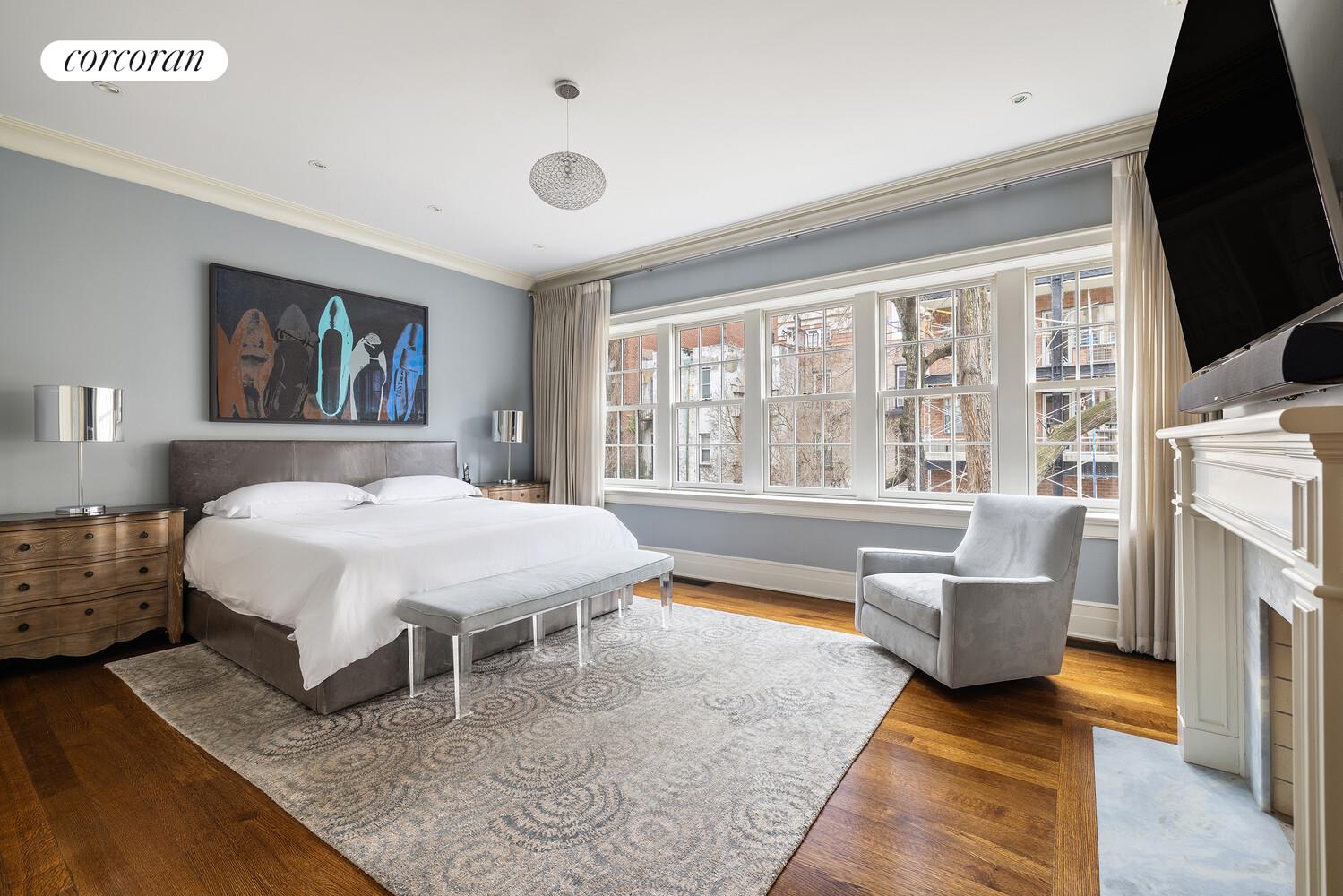 435 East 87th Street Manhattan, NY 10128 - Photo 18 of 36 a spacious bedroom with a bed a couch and large window