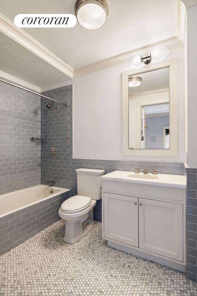 435 East 87th Street Manhattan, NY 10128 - Photo 25 of 36 a bathroom with a sink toilet mirror and shower