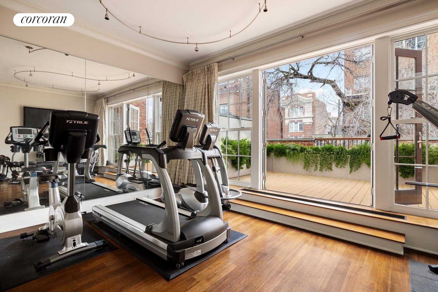 435 East 87th Street Manhattan, NY 10128 - Photo 31 of 36 a room with gym equipment and large windows