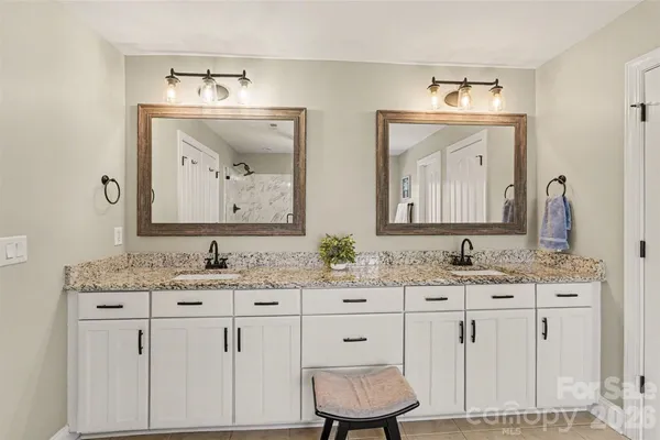 a bathroom with double vanity sinks and a mirror