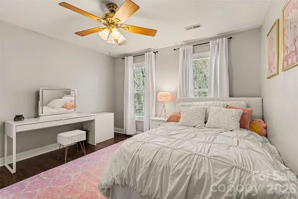 a bedroom with a bed and a table in it with window