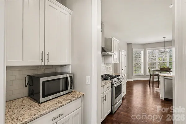 a kitchen with stainless steel appliances kitchen island granite countertop a stove and a microwave
