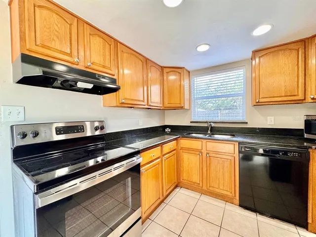 a kitchen with stainless steel appliances granite countertop a stove a sink and a microwave