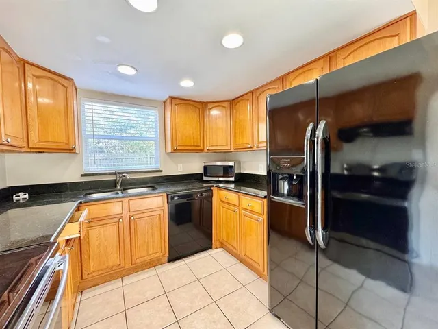 a kitchen with stainless steel appliances granite countertop a refrigerator and a sink