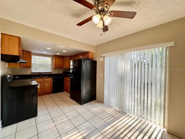 a kitchen with stainless steel appliances kitchen island granite countertop a refrigerator and a sink