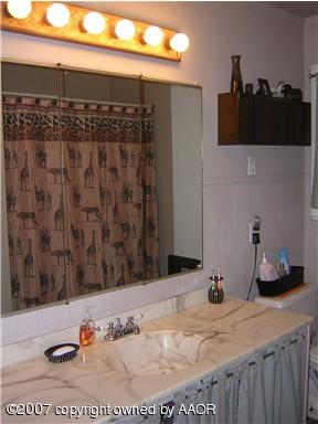 4616 South Bryan Street Amarillo, TX 79110 - Photo 5 of 12 a bathroom with a granite countertop sink and a mirror