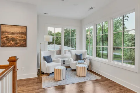 an empty room with windows and ceiling fan