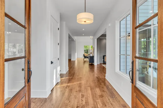 a view of hallway with wooden floor and chandelier