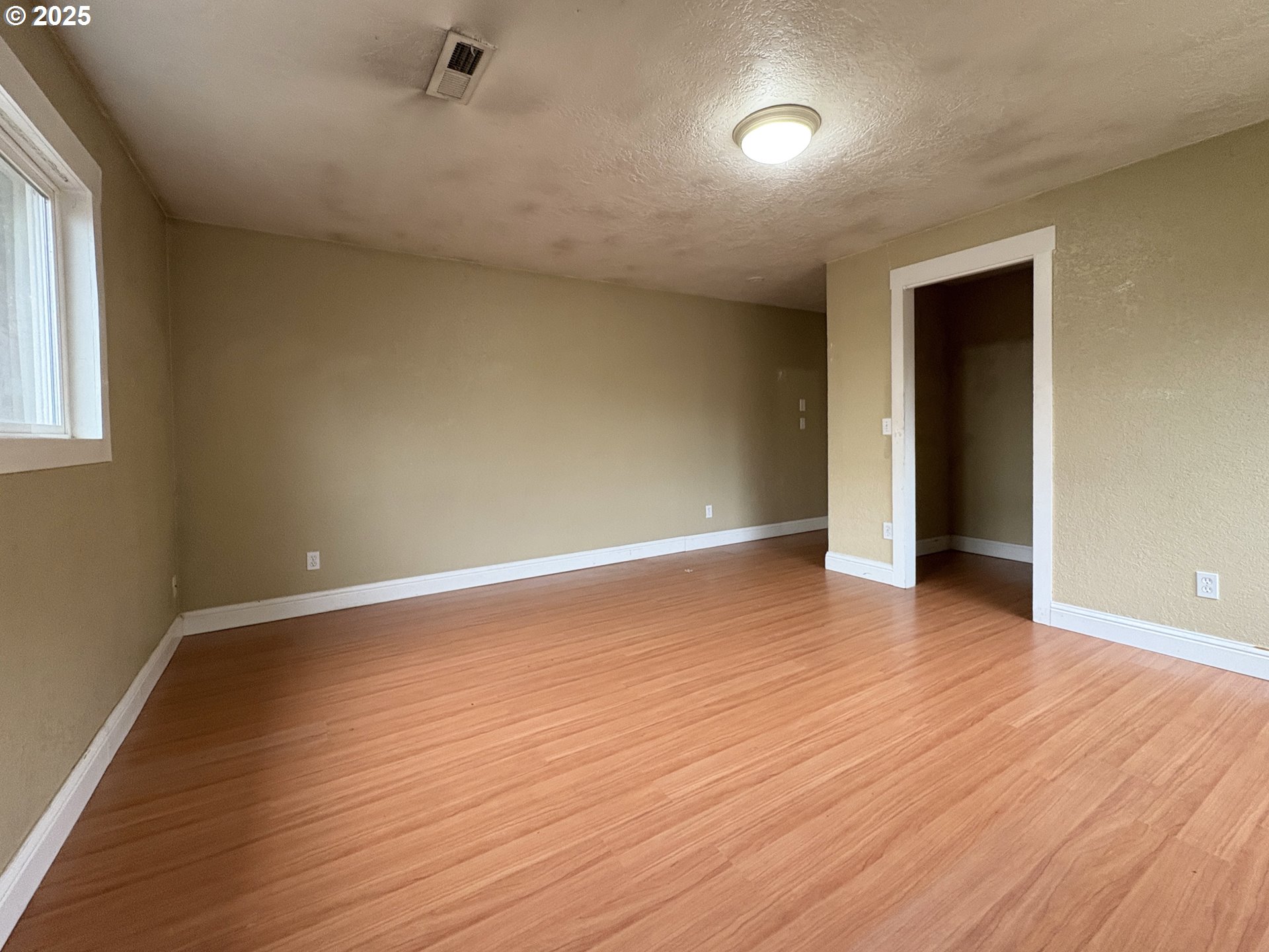 12305 Southwest 7th Street Beaverton, OR 97005 - Photo 13 of 23 a view of an empty room with wooden floor and a window