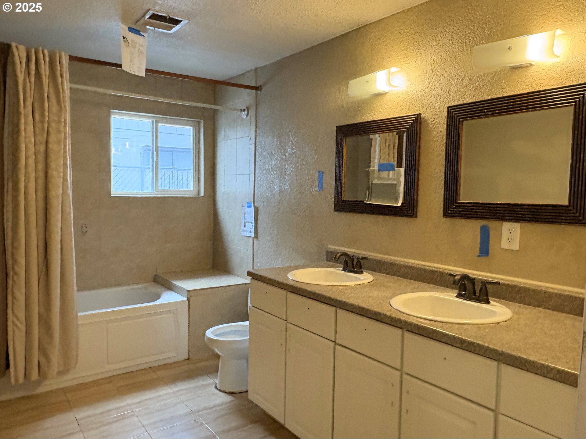 12305 Southwest 7th Street Beaverton, OR 97005 - Photo 9 of 23 a bathroom with a sink a toilet a mirror and bathtub