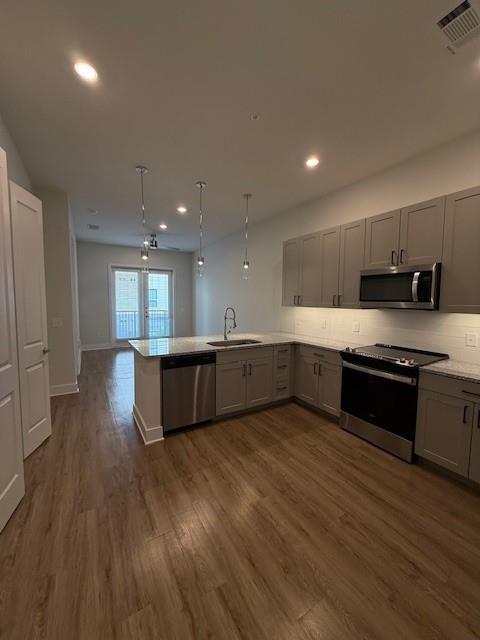 930 Ridgeview Drive, Unit 1262 Allen, TX 75013 - Photo 19 of 28 a large kitchen with stainless steel appliances granite countertop a stove a sink dishwasher and a oven with wooden floors