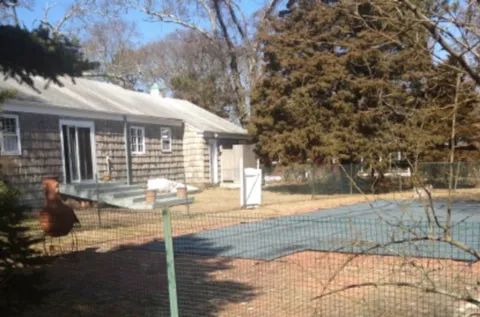 a view of a house with backyard and trees