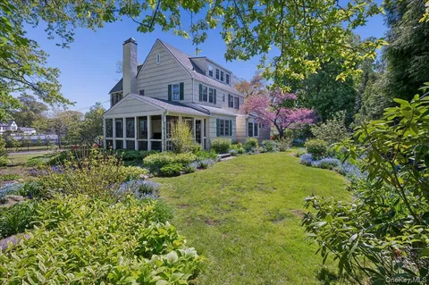 a view of a house with a yard and potted plants