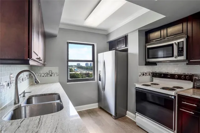 a bathroom with a granite countertop sink vanity mirror and toilet