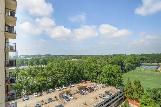 a kitchen with stainless steel appliances granite countertop a stove a refrigerator a microwave a dining table and chairs with wooden floor