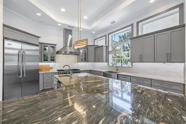 a bedroom with a bed next to a window with a chandelier