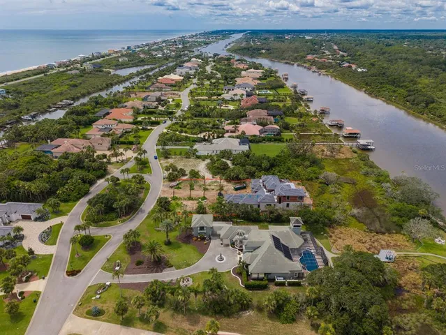 a kitchen with stainless steel appliances kitchen island granite countertop lots of wooden cabinets a sink a stove a dining table and chairs