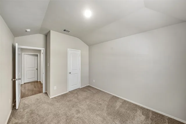 an empty room with closet and wooden door