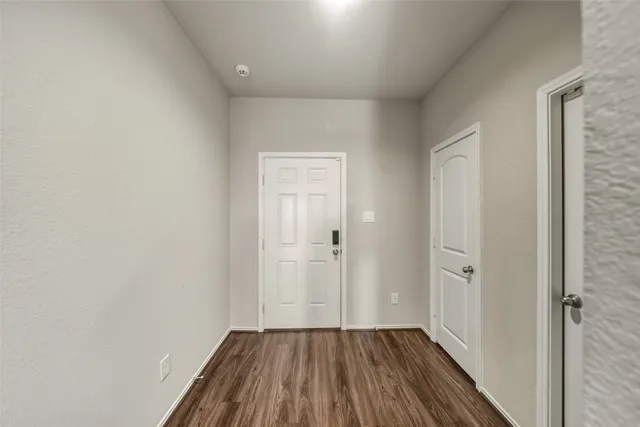 a view of a hallway with wooden floor
