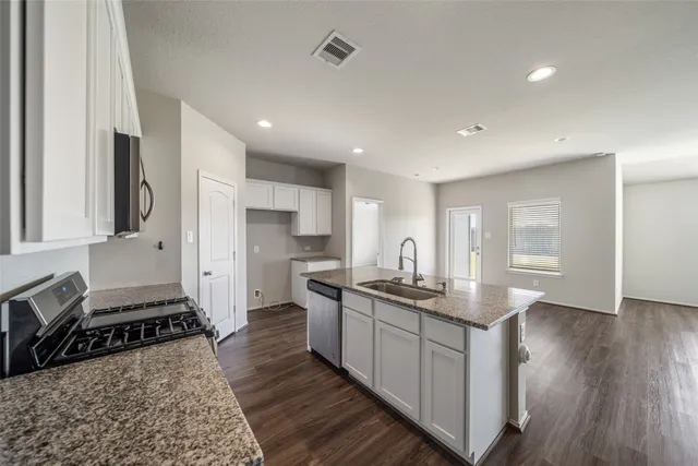 a kitchen with stainless steel appliances granite countertop a sink stove and refrigerator