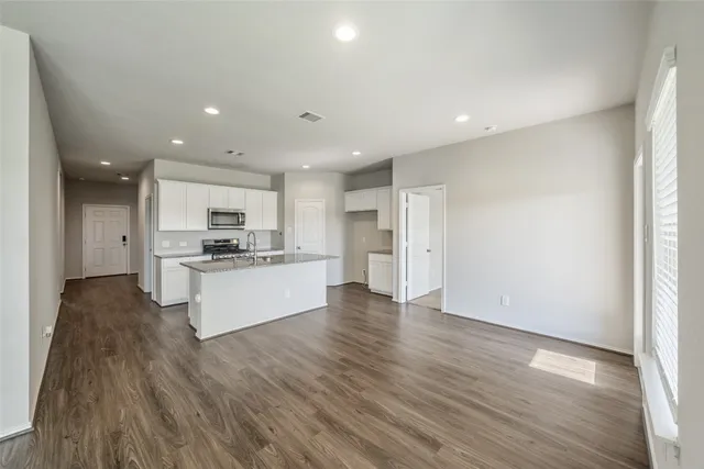 a view of kitchen with refrigerator sink white counter space and wooden floor