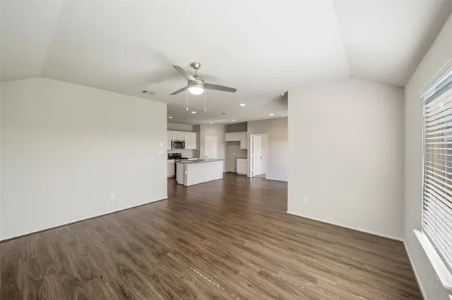 a view of empty room with wooden floor and window