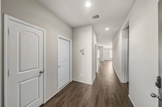a view of a hallway with wooden floor