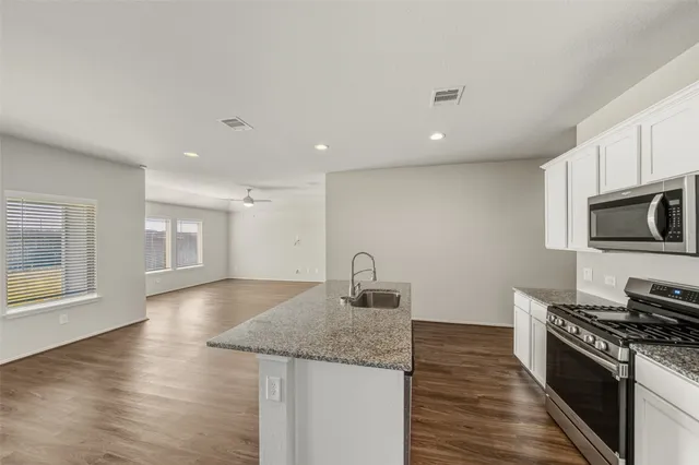 a kitchen with stainless steel appliances granite countertop a stove a sink and a refrigerator