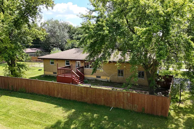 a view of a house with backyard and sitting area