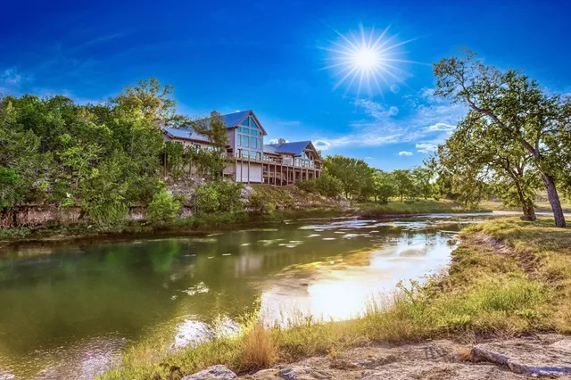 a view of a house with wooden deck front of house