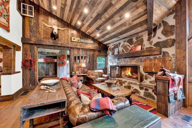 2983 East Ridgetop Road, Unit 27 Provo, UT 84604 - Photo 7 of 63 Rustic timber-beam great room featuring exposed wood-finish vaulted ceilings, a wood-burning fireplace with stone surround, and wood-finish flooring throughout