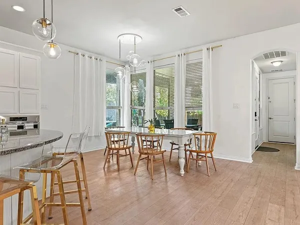 a kitchen with stainless steel appliances granite countertop a sink a stove and a table