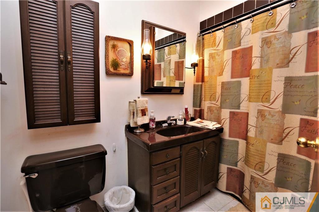 61 Ashley Road Edison, NJ 08817 - Photo 16 of 25 a bathroom with a sink a toilet and mirror