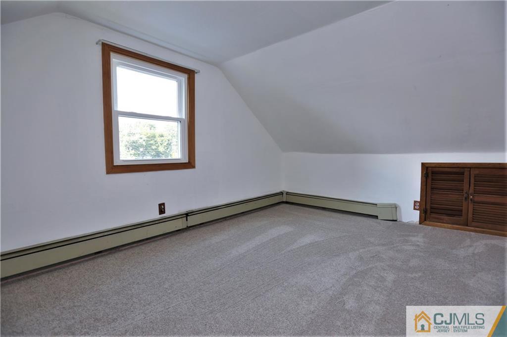 61 Ashley Road Edison, NJ 08817 - Photo 18 of 25 a view of an empty room with wooden floor and a window