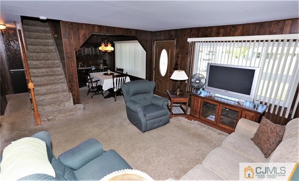61 Ashley Road Edison, NJ 08817 - Photo 3 of 25 a living room with furniture a flat screen tv and a fireplace
