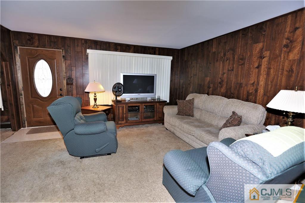 61 Ashley Road Edison, NJ 08817 - Photo 4 of 25 a living room with furniture a large window and a fireplace