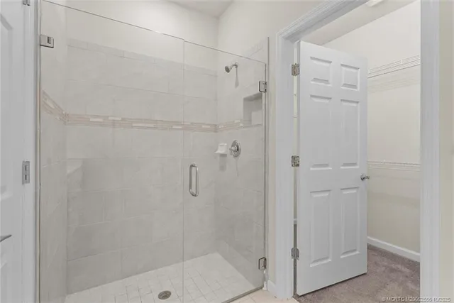 a view of a room with a chandelier fan and a window