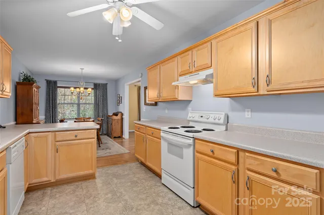 a large kitchen with stainless steel appliances granite countertop a stove sink and cabinets