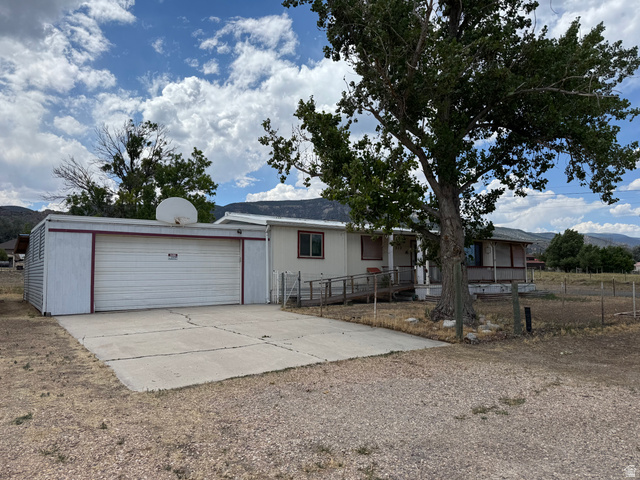 210 South State Street Moroni, UT 84646 - Photo 1 of 23 Single-story residence featuring a carport with an attached garage, a concrete driveway, and a covered porch with a ramp entrance