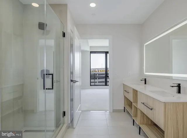a bathroom with a double vanity sink and shower
